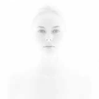 A high-key portrait of a person against a bright white backg