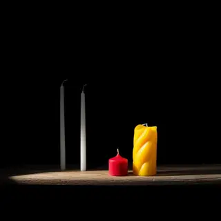 A tall thin white candle, a short fat red candle, and a medi