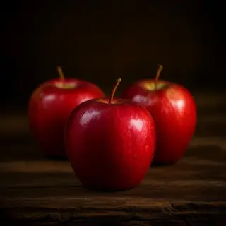 Exactly 3 red apples arranged on a wooden table