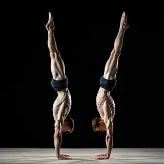 Two gymnasts performing a synchronized handstand, side by si