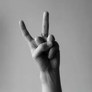 A person making a peace sign with their right hand, clearly 