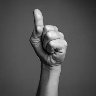 A hand giving a thumbs-up with four fingers curled and thumb