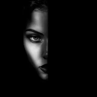 A portrait with dramatic split lighting — half the face brig