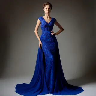 A woman wearing a royal blue evening dress against a neutral