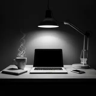 A desk scene: laptop in the center, coffee mug to the left, 