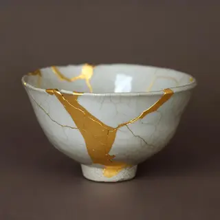 A Japanese kintsugi bowl — cracked ceramic repaired with vis
