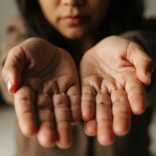 A woman holding her hands out in front of her palms-up, all 