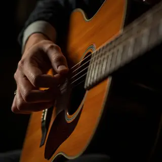 A person playing an acoustic guitar with left hand on the fr