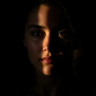 A portrait with dramatic split lighting — half the face brig