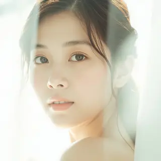 A high-key portrait of a person against a bright white backg