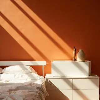 A bedroom wall painted in #FF6B35 (burnt orange) with white 