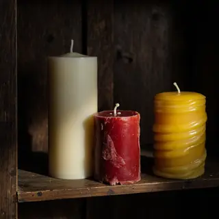 A tall thin white candle, a short fat red candle, and a medi