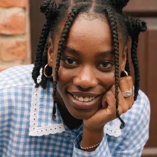 A close-up portrait of a young woman with a warm natural smi