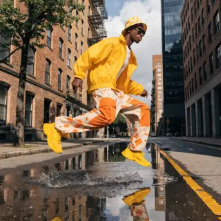 A man captured mid-jump over a puddle, body in the air with 