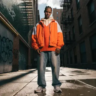 A person standing with both hands visible at their sides, fi