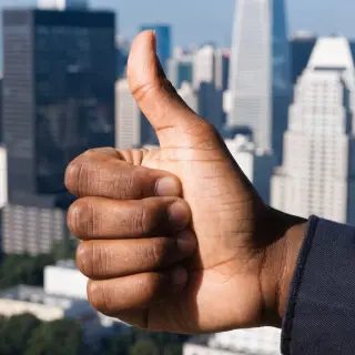 A hand giving a thumbs-up with four fingers curled and thumb