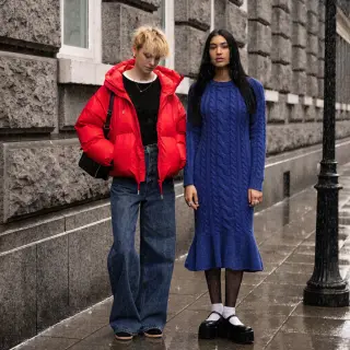 Two women standing side by side: one with short blonde hair 