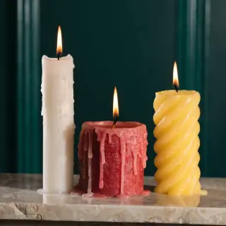 A tall thin white candle, a short fat red candle, and a medi