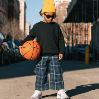A child holding a basketball, both at correct relative sizes