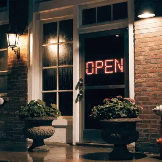 The word 'OPEN' displayed on a red LED sign with glowing pix
