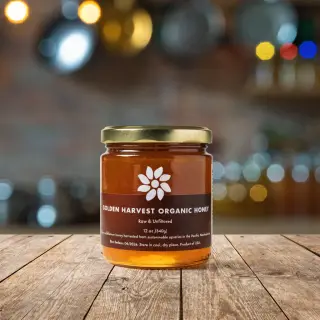 A product label for 'GOLDEN HARVEST ORGANIC HONEY' with subt