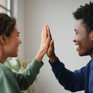 Two people doing a high-five, palms meeting with all fingers