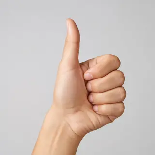 A hand giving a thumbs-up with four fingers curled and thumb