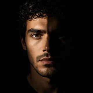 A portrait with dramatic split lighting — half the face brig