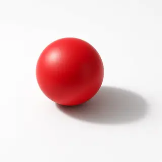 A red sphere on a white surface with a single shadow cast to